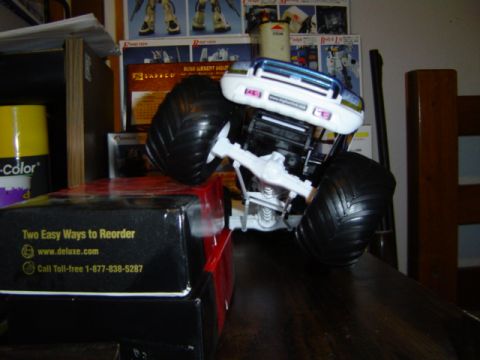 1979 Ford Bronco - Toy monster truck with large tires sits on a table next to boxes.