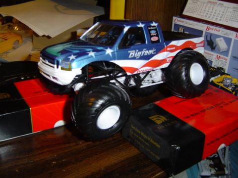 1979 Ford Bronco - Toy Bigfoot monster truck with American flag paint scheme sits on a table.
