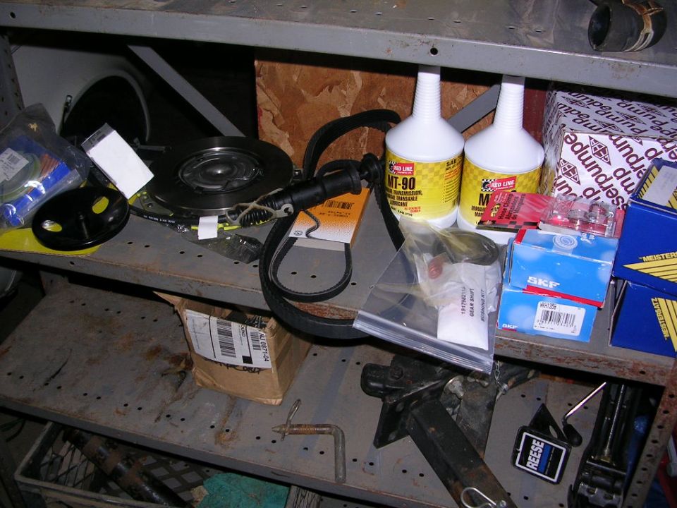 Workbench shelf with Red Line MT-90 gear oil, clutch parts, timing belt and SKF bearing boxes