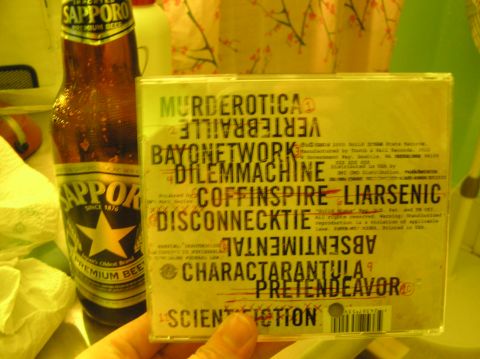 1997 Ford Probe - A CD case various band names is held next to a bottle of Sapporo Premium Beer.