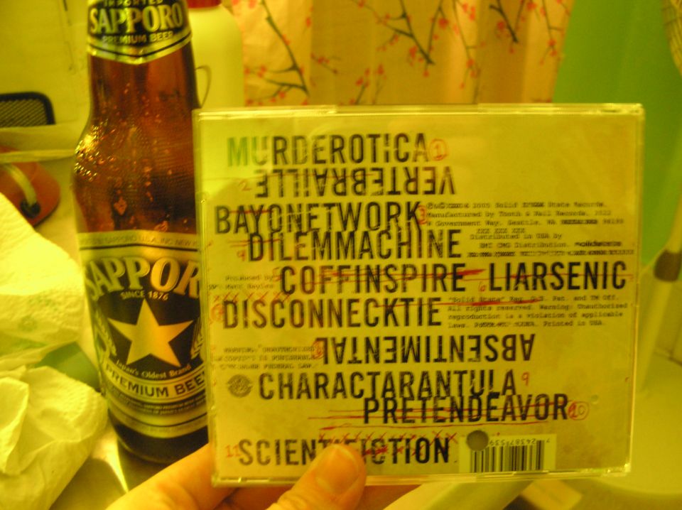 CD case with band names and Sapporo beer bottle