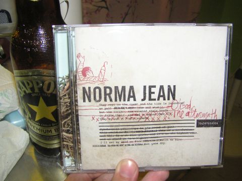 1997 Ford Probe - A CD case album art and song lyrics is placed next to a bottle of Sapporo Premium Beer.