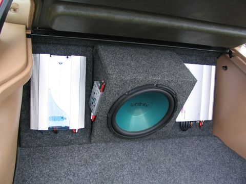 1997 Ford Probe - Car trunk interior shows a subwoofer and two amplifiers installed in a custom carpeted enclosure.