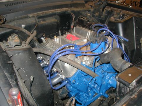 1968 Ford Mustang - Close-up view of a vehicle's engine bay, a blue-painted engine block and silver valve covers.