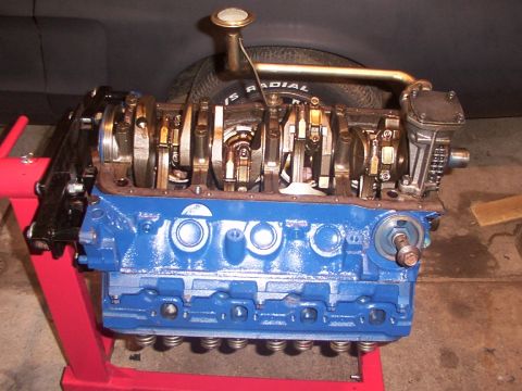 1968 Ford Mustang - A blue V8 engine block is mounted on a red engine stand, showing internal components.