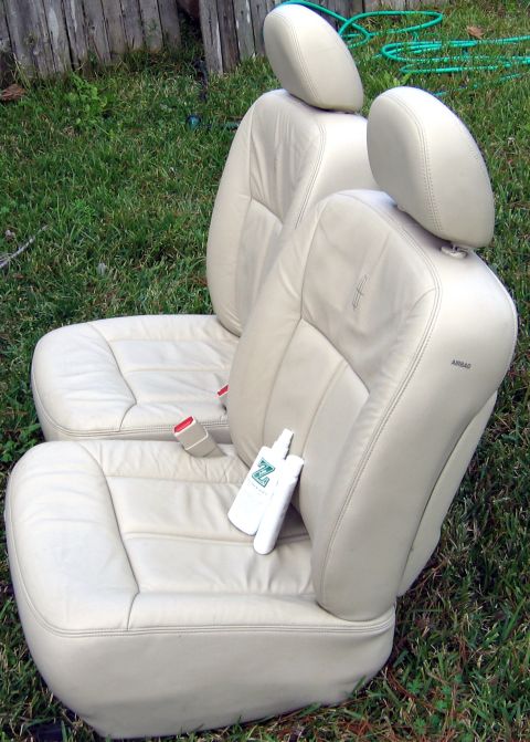 2000 Ford Crown Victoria - Tan leather car seats with "AIRBAG" label visible, likely removed from a vehicle for cleaning or replacement.