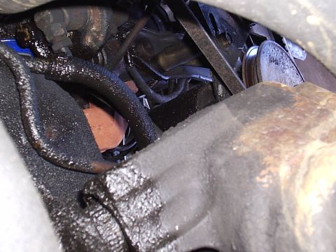 1985 Ford Bronco - Close-up view of engine components covered in oil and grime.