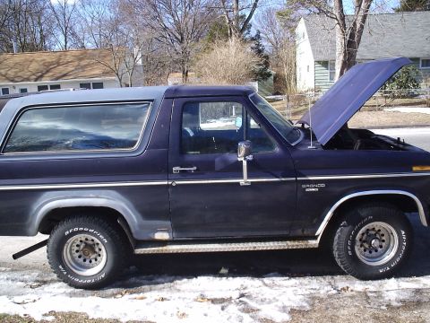 1985 Ford Bronco - Ford Bronco side profile with hood up, showing engine bay. Appears to be an early 1980s model.