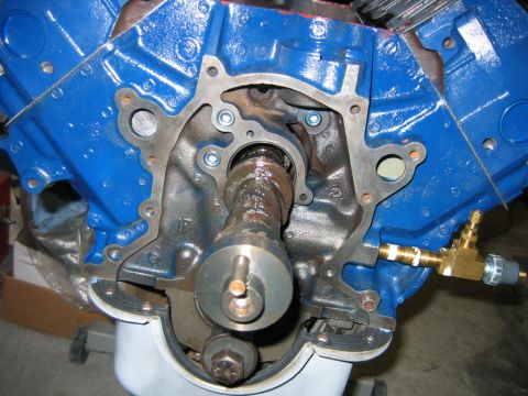 1992 Ford Bronco - Close-up of the front of a blue engine block with the timing cover removed, exposing the camshaft snout, front gasket surface, and timing g…
