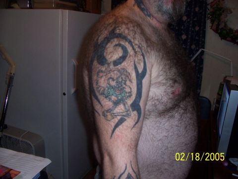 1989 Ford Bronco - A man displays a tattoo on his arm tribal art and a whimsical cartoon figure.