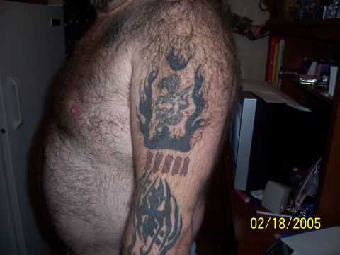 1989 Ford Bronco - A tattoo on an arm features a figure surrounded by flames and the word 'RUMBA'.