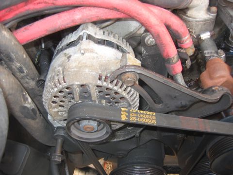 1989 Ford Bronco - Close-up of an alternator and drive belt, with part numbers visible.