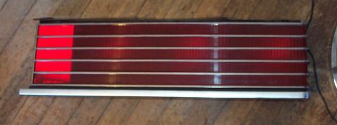 1985 Ford LTD Crown Victoria - This taillight assembly features horizontal chrome trim and distinct red sections, likely for a vehicle part.