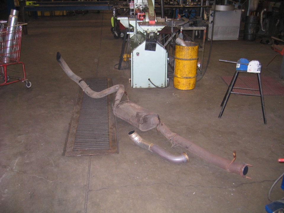 Exhaust system pipe and muffler assembly on a shop floor