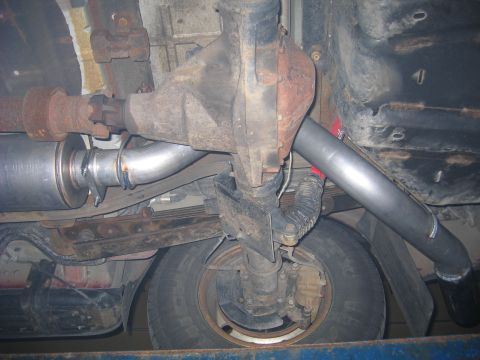 2000 Ford Excursion - Custom exhaust system components visible from underneath the vehicle, including a muffler and piping.