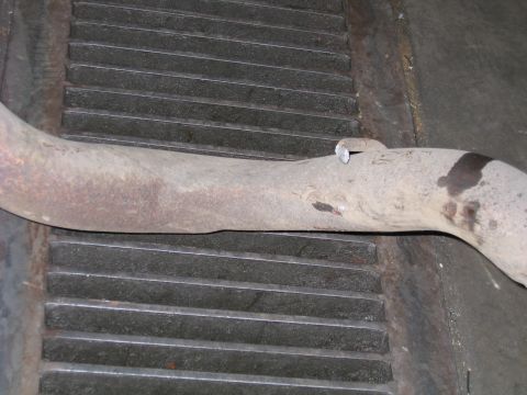 2000 Ford Excursion - Close-up of an exhaust pipe section on a metal grate.