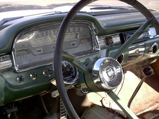 Dashboard of a 1959 Ford Ranchero with a green dash, chrome accents, and a large steering wheel