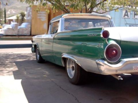 1959 Ford Ranchero - The rear of a green 1959 Ford Ranchero pickup truck is visible from the side, with chrome accents and distinctive taillights.
