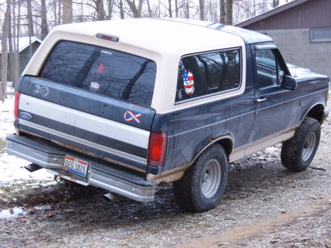 1993 Ford Bronco - Rear view of a two-tone Ford Bronco, showing its license plate and side profile.