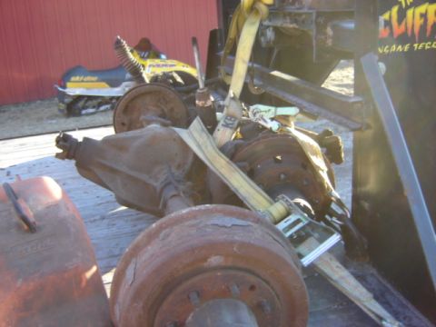 1992 Ford Bronco - Trailer loaded with vehicle axles and parts, a snowmobile is visible in the background.