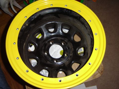 1992 Ford Bronco - A close-up view of a yellow-rimmed steel wheel with a black center.