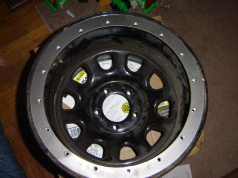 1992 Ford Bronco - A steel wheel with a beadlock ring is shown, with a yellow safety sticker visible inside.