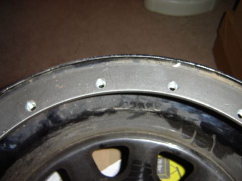 1992 Ford Bronco - A close-up view of a vehicle's wheel rim, showing its construction and lug nut mounting points.