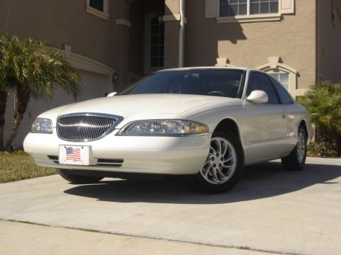 1997 Lincoln Mark VIII - A white 1997 Lincoln Mark VIII is parked in a driveway with a house in the background.