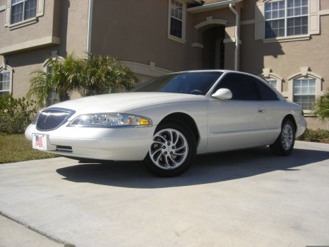 1997 Lincoln Mark VIII - A white 1997 Lincoln Mark VIII is parked on a concrete driveway in front of a beige house.