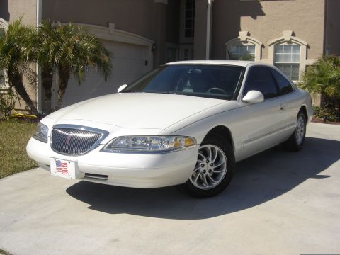 1997 Lincoln Mark VIII - A white 1997 Lincoln Mark VIII is parked on a concrete driveway in front of a house with palm trees.