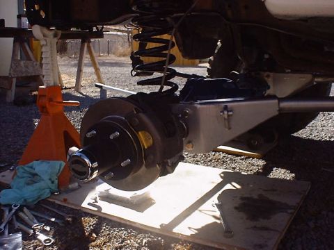 1988 Ford Bronco - The vehicle's rear suspension and brake assembly are visible, with tools laid out nearby.