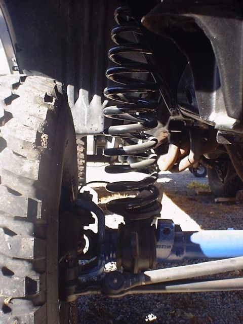 1988 Ford Bronco - Detail shot of a vehicle's suspension system and tire, with a Supermotors watermark visible.
