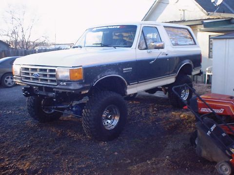 1988 Ford Bronco - This modified Ford Bronco sits high on large off-road tires, a two-tone paint scheme and aftermarket front bumper.