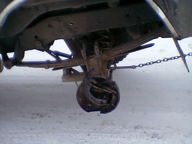 Rear axle assembly with leaf springs and a damaged brake drum