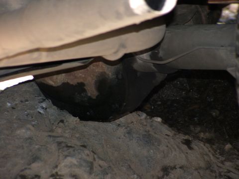 1980 Ford Bronco - A close-up view of the undercarriage reveals the exhaust system and suspension components of a vehicle.