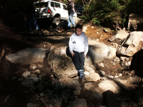 1980 Ford Bronco - A group navigates a challenging rocky path with off-road vehicles, while a child observes the action.