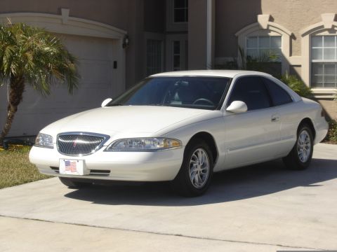 1997 Lincoln Mark VIII - This 1997 Lincoln Mark VIII coupe is shown in a three-quarter front view, parked in front of a residential garage.