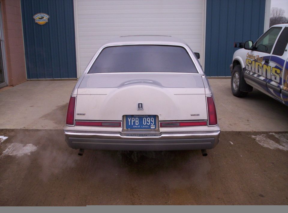 Rear view of a 1992 Lincoln Mark VII with a spare tire cover and a blue license plate