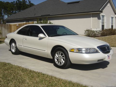 1997 Lincoln Mark VIII - A white 1997 Lincoln Mark VIII coupe is parked in front of a house.