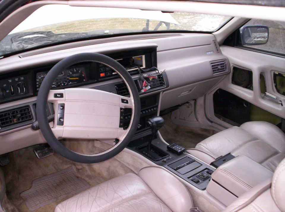 Cream leather interior of a Lincoln coupe with console shifter and gauges