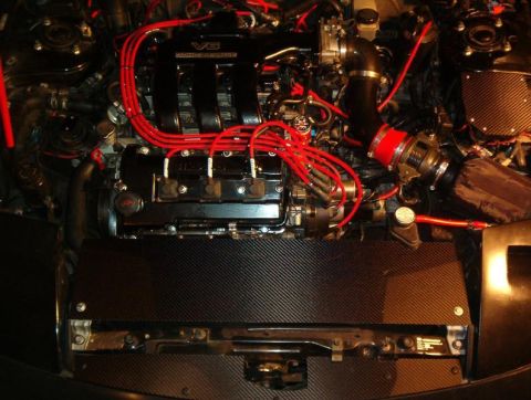 1995 Ford Probe - Engine bay a V6 engine with red spark plug wires and an aftermarket intake system.