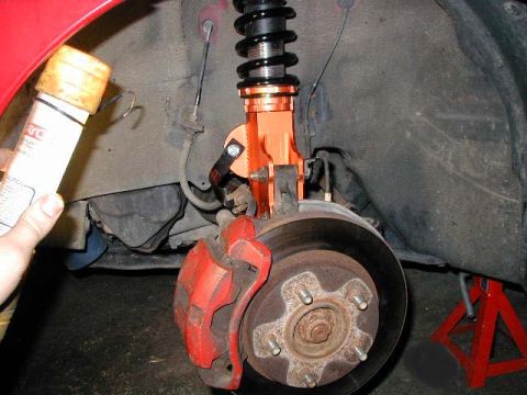 1994 Ford Probe - Close-up of a car's suspension system, focusing on the brake caliper and coilover assembly.