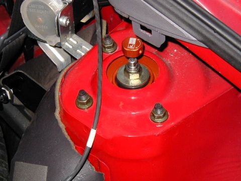 1994 Ford Probe - Close-up of an orange K-Sport adjustable strut mount installed on a red vehicle's suspension tower.