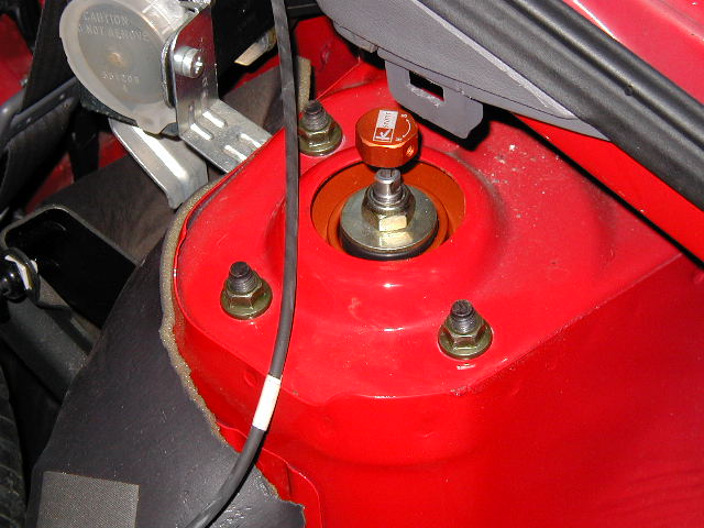 Orange K-Sport adjustable strut mount on red vehicle