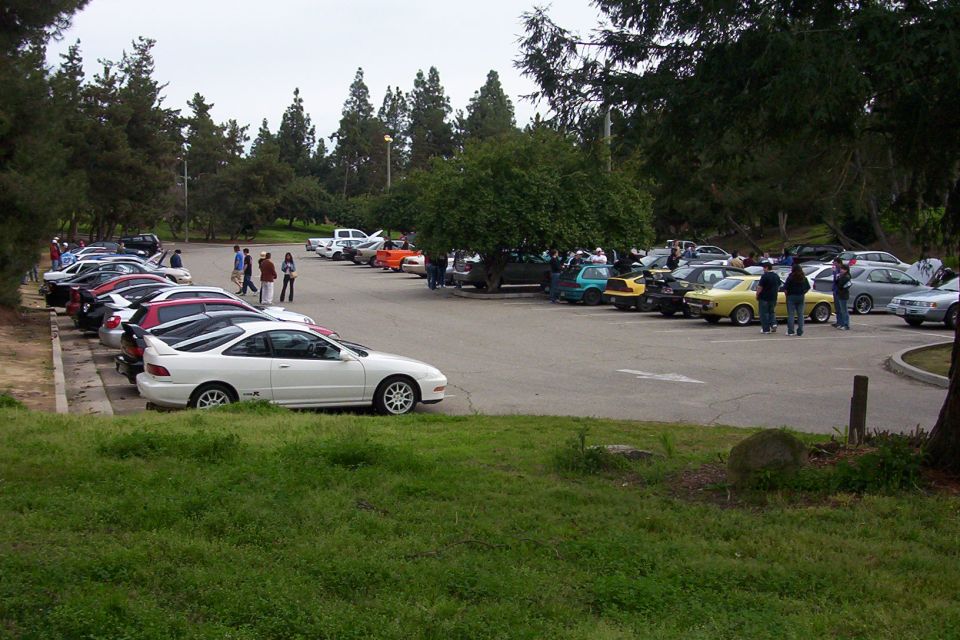 White coupe with spoiler parked in a lot full of cars