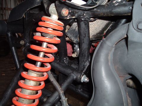1995 Mercury Grand Marquis - Detail of ATV suspension components, including a red shock absorber and black frame.