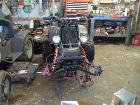 1995 Mercury Grand Marquis - This ATV is in a garage, possibly undergoing repairs, with a lawn tractor nearby.