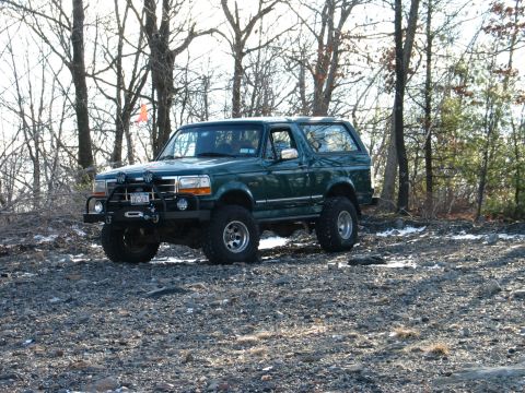 1995 Ford Bronco - This 1995 Ford Bronco, modified for off-road use, is parked in a wooded area.