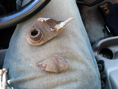 1995 Ford Bronco - A broken metal part is shown on a person's lap inside a vehicle.