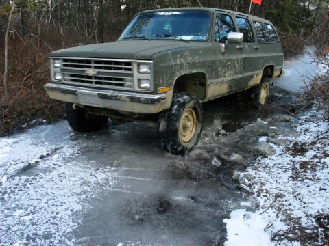 1995 Ford Bronco - This Chevrolet Suburban is navigating a challenging icy and muddy terrain.